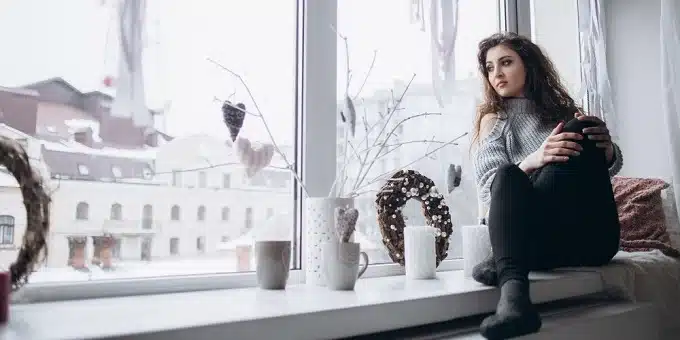 elegáns lány ül ablakpárkányon
