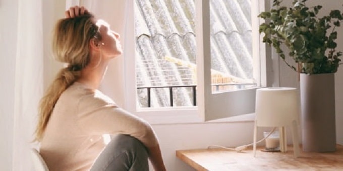 fiatal nő az ablak előtt az ablak árakról elmélkedik