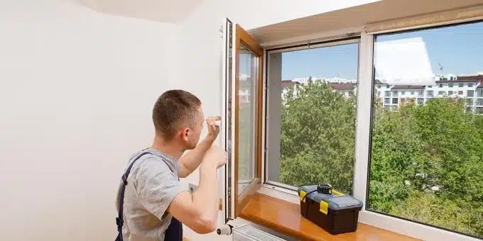 ablakkilincset állít be egy férfi szerelő
