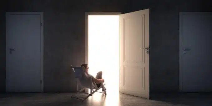 olcsó beltéri ajtó - félig nyitott ajtóban egy férfi pihen egy fotelben