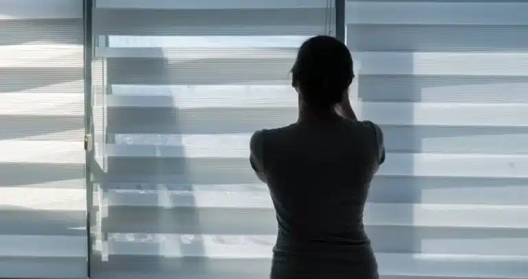 roló ablakra - fiatal nő egy résreluxát állít be